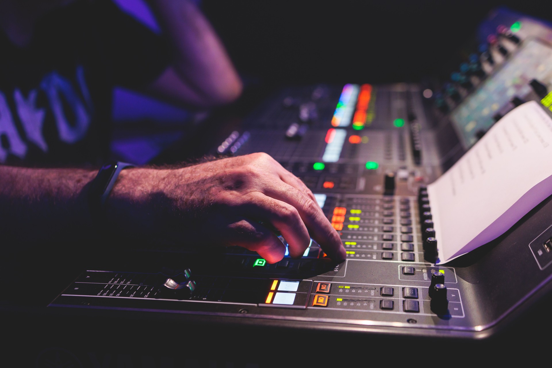 View of lighting technician operator working on mixing console workplace during live conference event, concert show broadcast, light mixer controller panel, workplace sound professional equipment